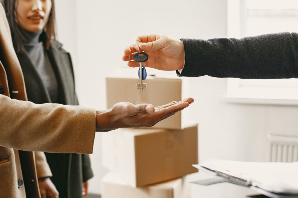 Hands passing a set of apartment keys